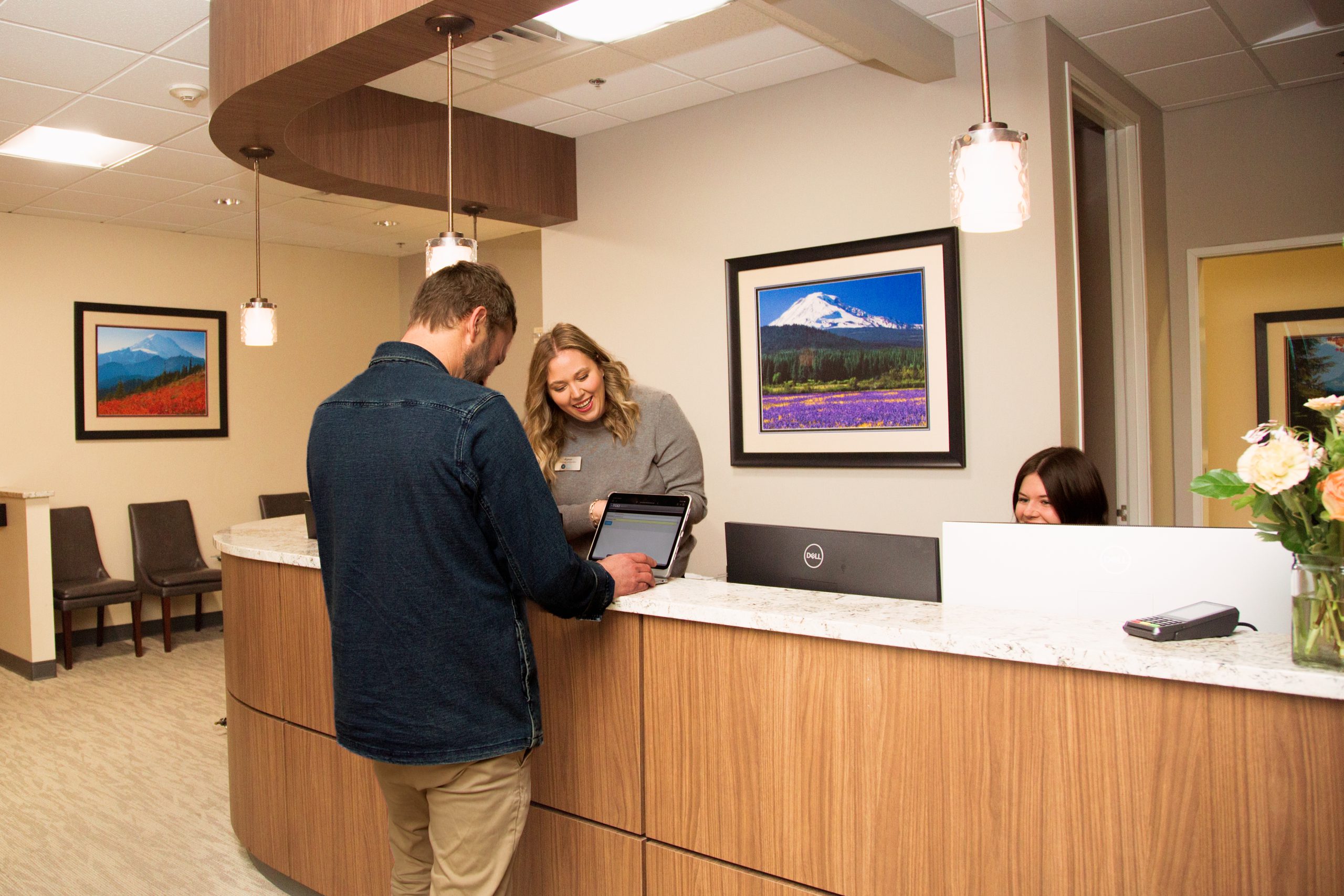 An image of a customer by the counter with a staff / team member.